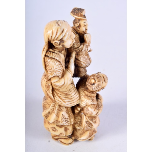 29 - A 19TH CENTURY JAPANESE MEIJI PERIOD CARVED IVORY OKIMONO modelled as a male with two other figures.... 