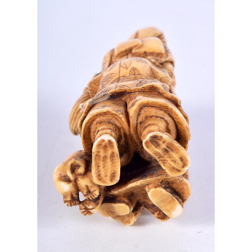 29 - A 19TH CENTURY JAPANESE MEIJI PERIOD CARVED IVORY OKIMONO modelled as a male with two other figures.... 