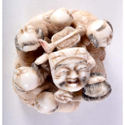 47 - A 19TH CENTURY JAPANESE MEIJI PERIOD CARVED IVORY OKIMONO modelled as numerous figures holding masks... 