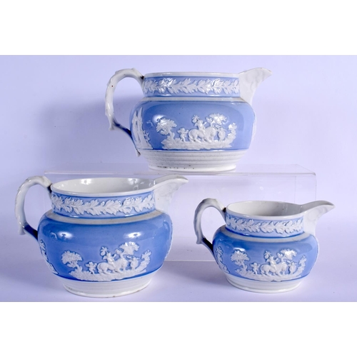 156 - THREE GRADUATED ENGLISH PORCELAIN JUGS WITH LIGHT BLUE GROUND RELIEF MOULDED WITH COUNTRY SCENES 11.... 