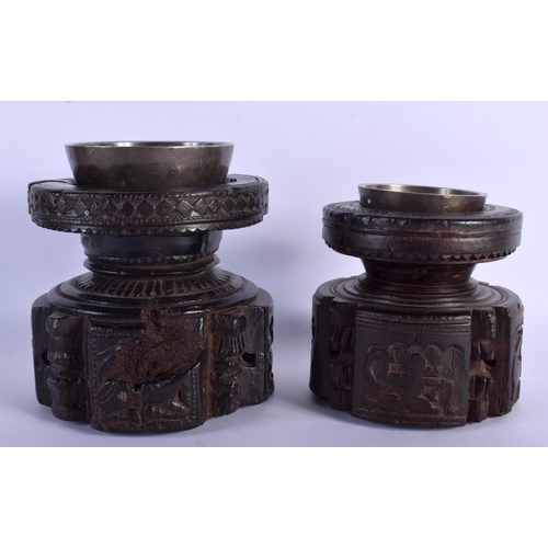 339 - A RARE NEAR PAIR OF 17TH/18TH CENTURY INDIAN CARVED WOOD MORTARS carved with Buddhistic figures. Lar... 
