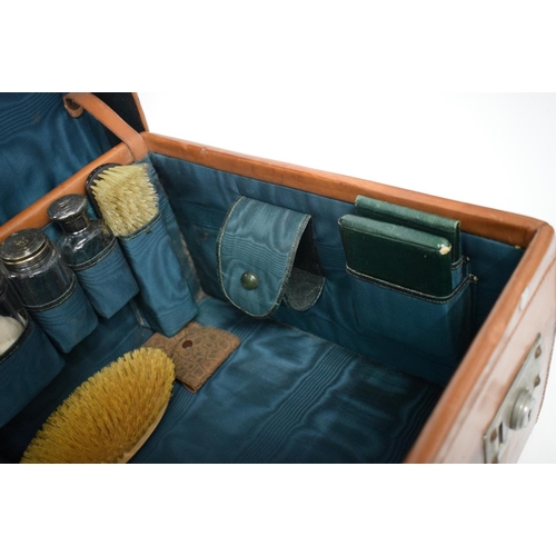 428 - AN ANTIQUE LEATHER CASED TRAVELLING SILVER VANITY CASE with fitted interior. 42 cm x 32 cm x 22 cm.