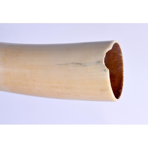 442 - A RARE 19TH CENTURY AFRICAN TRIBAL CARVED IVORY OLIPHANT INSTRUMENT with figural terminal. 54 cm lon... 