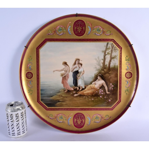 61 - A LARGE EARLY 20TH CENTURY VIENNA PORCELAIN CHARGER painted with four figures within a landscape. 42... 
