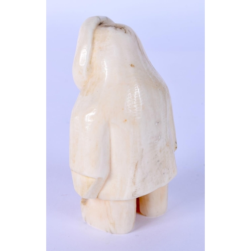 20 - A RARE EARLY 20TH NORTH AMERICAN CARVED IVORY FIGURE OF AN ESKIMO possibly tribal. 7 cm x 4 cm.