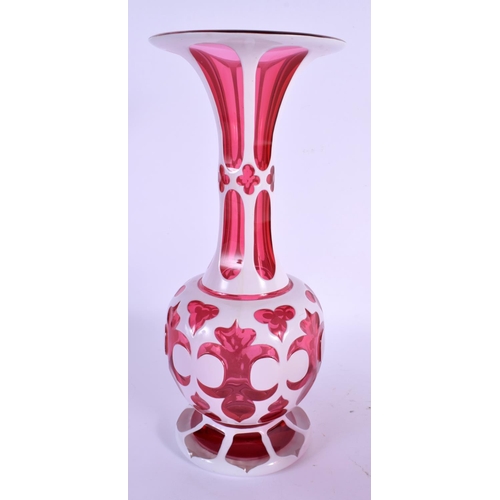 15 - A BOHEMIAN RUBY AND WHITE OVERLAID FLASH VASE ON STAND decorated with motifs. 27 cm high.