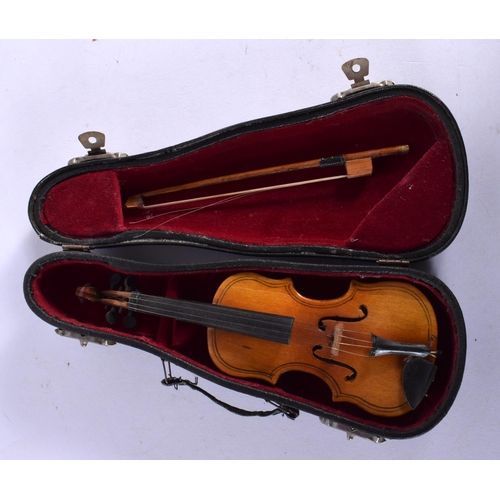 297 - A CASED VINTAGE MINIATURE VIOLIN with bow. 16 cm long.