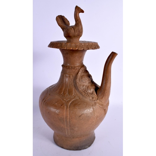 30 - A LARGE ANTIQUE EASTERN INDIAN POTTERY EWER decorated with mask heads, formed with a seated bird. 35... 