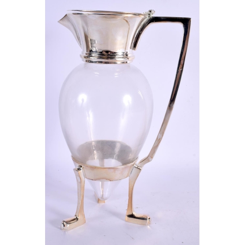 354 - A STYLISH SILVER PLATED GLASS CLARET JUG in the manner of Christopher Dresser. 28 cm high.