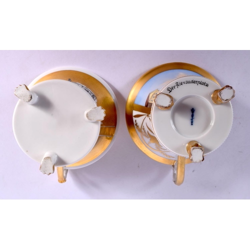 36 - A FINE PAIR OF KPM BERLIN CUPS AND SAUCERS highlighted in gilt and painted with landscapes. 10 cm di... 