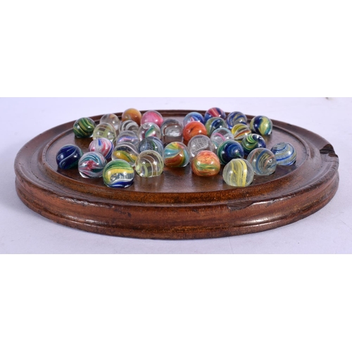 381 - A SOLITAIRE MARBLE BOARD with marbles. Board 15 cm diameter. (qty)