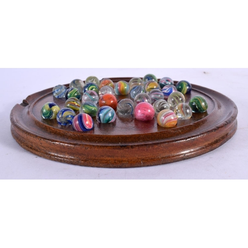 381 - A SOLITAIRE MARBLE BOARD with marbles. Board 15 cm diameter. (qty)