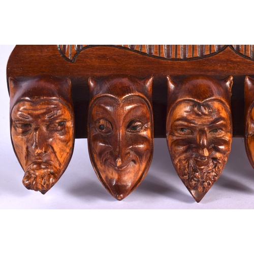 387 - A RARE EARLY 20TH CENTURY EUROPEAN CARVED WOOD WALL MOUNTED PIPE RACK formed as mischievous mask hea... 