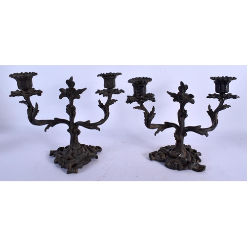 453 - A PAIR OF 19TH CENTURY BRONZE TWIN HANDLED CANDLESTICKS of scrolling form. 24 cm x 22 cm.