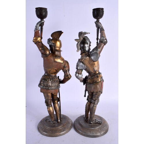 455 - A LARGE PAIR OF ANTQUE COLD PAINTED CONTINENTAL METAL CANDLESTICKS formed as Knights. 39 cm high.