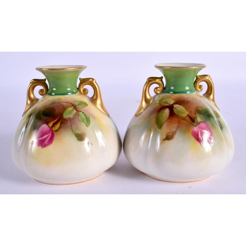 67 - A PAIR OF ROYAL WORCESTER TWIN HANDLED PORCELAIN VASES painted with roses. 9 cm x 6 cm.