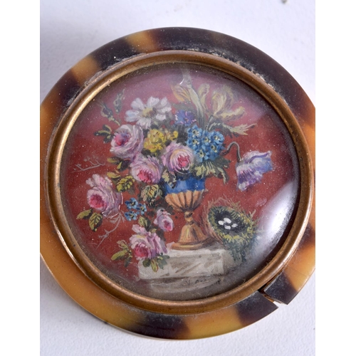 766 - A TORTOISESHELL BOX AND COVER WITH A FLORAL INSET.  5cm x 1.5cm