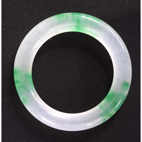 833 - A TWO TONE JADE BANGLE.  Internal 5.5cm diameter, weight 66g