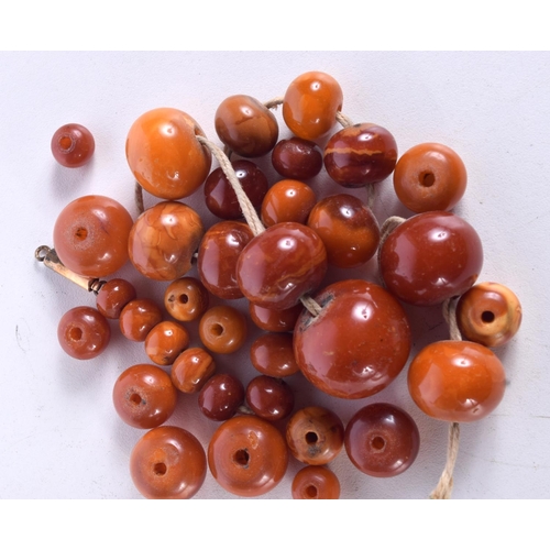 864 - A STRING OF AMBER BEADS.  Largest bead 24.6mm, weight 69g