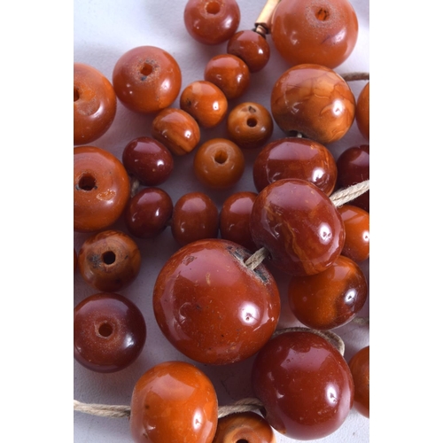 864 - A STRING OF AMBER BEADS.  Largest bead 24.6mm, weight 69g