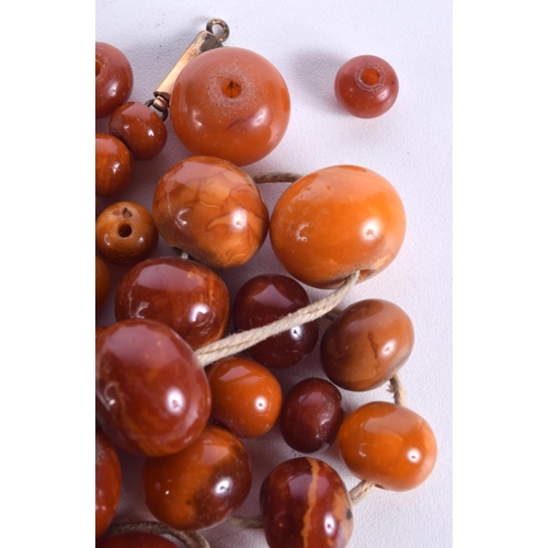 864 - A STRING OF AMBER BEADS.  Largest bead 24.6mm, weight 69g