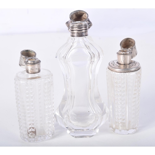 869 - THREE SILVER TOPPED SCENT BOTTLES.  Largest 11.4cm high (3)