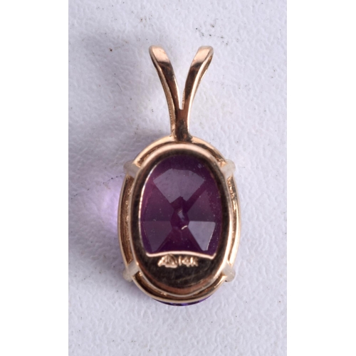 873 - A 14CT GOLD AND AMETHYST PENDANT.  2.1cm x 1cm, weight 2.2g