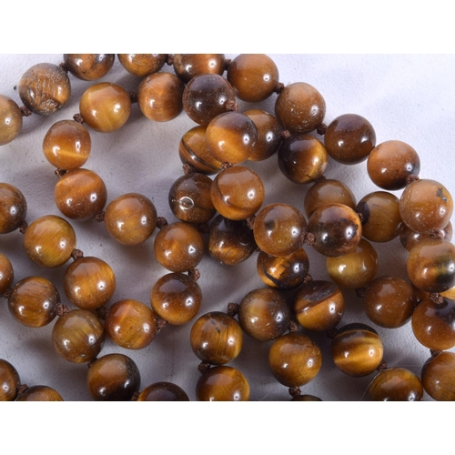 919 - A STRING OF TIGERS EYE TYPE BEADS.  Length 126cm, weight 98g, Bead size 7.7mm