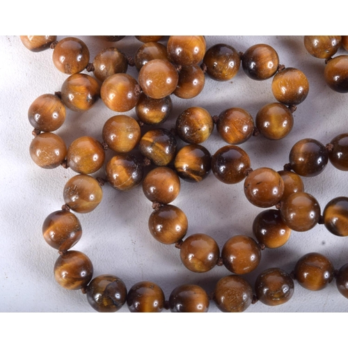 919 - A STRING OF TIGERS EYE TYPE BEADS.  Length 126cm, weight 98g, Bead size 7.7mm