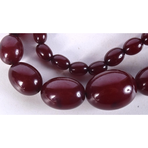 957 - CHERRY AMBER TYPE NECKLACE.  Largest bead 20.9mm, weight 65g