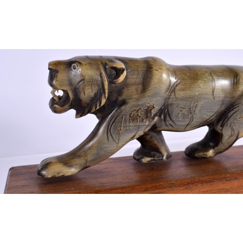 1520 - A PAIR OF 19TH CENTURY CARVED MIDDLE EASTERN RHINOCEROS HORN TIGERS modelled roaming upon wood bases... 