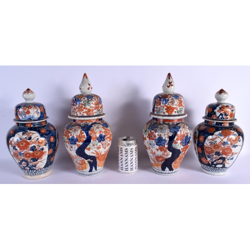 1554 - TWO PAIRS OF 19TH CENTURY JAPANESE MEIJI PERIOD IMARI VASES AND COVERS painted with foliage. 36 cm x... 