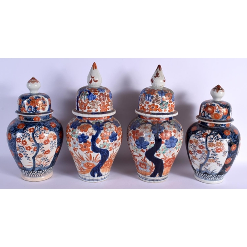 1554 - TWO PAIRS OF 19TH CENTURY JAPANESE MEIJI PERIOD IMARI VASES AND COVERS painted with foliage. 36 cm x... 