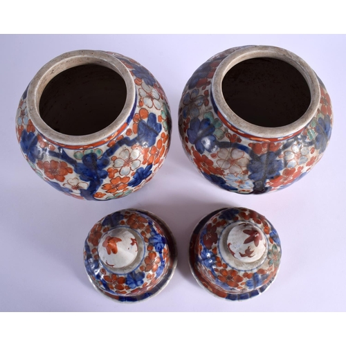 1554 - TWO PAIRS OF 19TH CENTURY JAPANESE MEIJI PERIOD IMARI VASES AND COVERS painted with foliage. 36 cm x... 