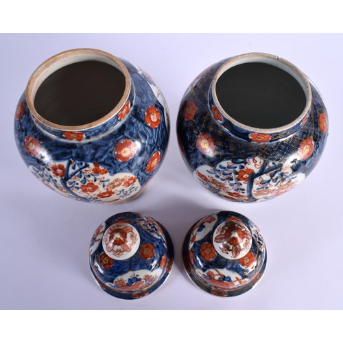 1554 - TWO PAIRS OF 19TH CENTURY JAPANESE MEIJI PERIOD IMARI VASES AND COVERS painted with foliage. 36 cm x... 