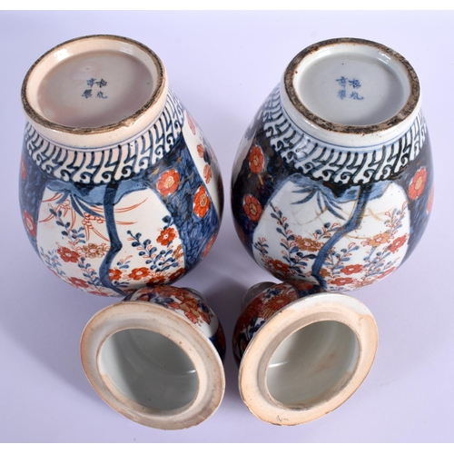 1554 - TWO PAIRS OF 19TH CENTURY JAPANESE MEIJI PERIOD IMARI VASES AND COVERS painted with foliage. 36 cm x... 