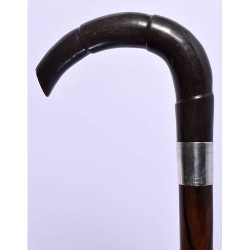 340 - AN ANTIQUE SILVER MOUNTED CARVED RHINOCEROS HORN WALKING CANE. 86 cm long.