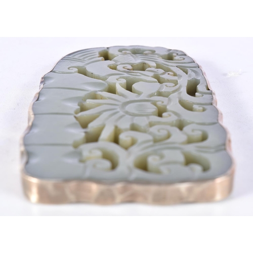 3025 - A carved Chinese  jade pendant with a white metal border 10.5 x 5.5 cm.