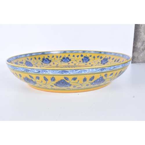 3162 - A large Chinese porcelain yellow ground glazed dish decorated with fish and algae. 34cm.