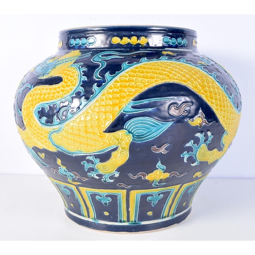 3174 - A large Chinese porcelain Fahua jar decorated in relief with dragons and clouds. 28 x 35cm.