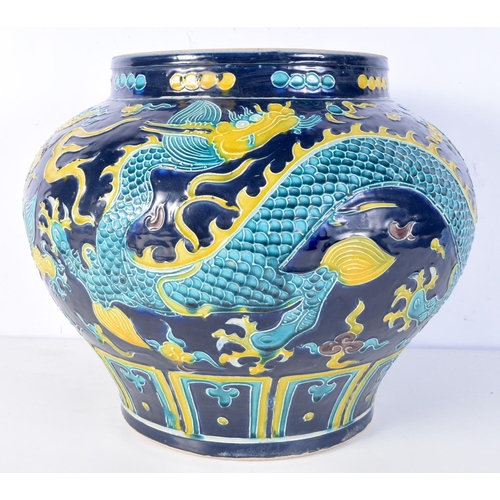 3174 - A large Chinese porcelain Fahua jar decorated in relief with dragons and clouds. 28 x 35cm.