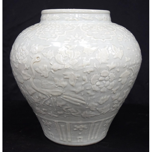 3175 - A large Chinese porcelain celadon jar decorated in relief with cranes and a phoenix. 34 x 34cm.