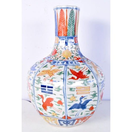 3183 - A Chinese porcelain octagonal sided Wucai vase decorated with cranes in panels. 31cm high.