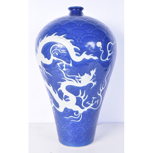 3188 - A large Chinese porcelain sacrificial blue Meiping vase decorated in relief with dragons and clouds.... 