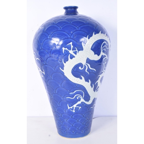 3188 - A large Chinese porcelain sacrificial blue Meiping vase decorated in relief with dragons and clouds.... 