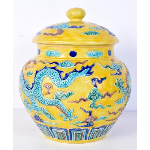 3193 - A Chinese porcelain Fahua jar and cover decorated in relief with dragons and clouds. 24cm high.