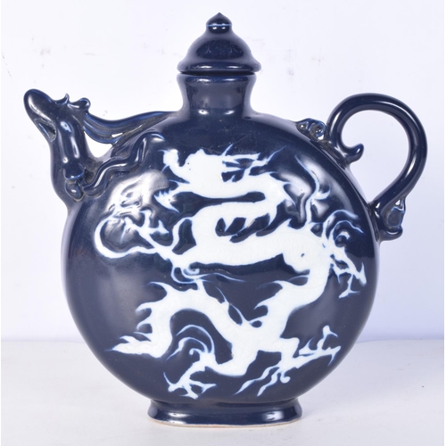 3194 - A Chinese porcelain sacrificial blue lidded jug decorated in relief with a dragon. 22cm high.