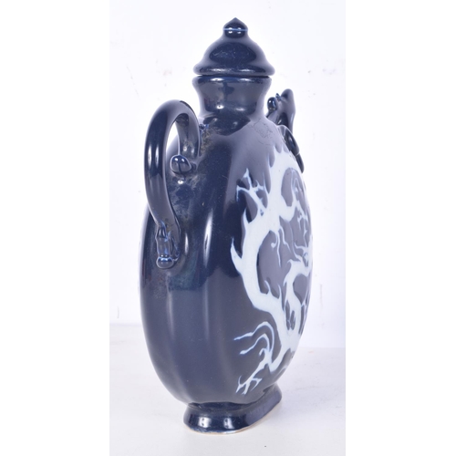 3194 - A Chinese porcelain sacrificial blue lidded jug decorated in relief with a dragon. 22cm high.