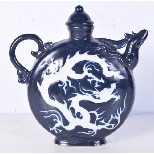 3194 - A Chinese porcelain sacrificial blue lidded jug decorated in relief with a dragon. 22cm high.