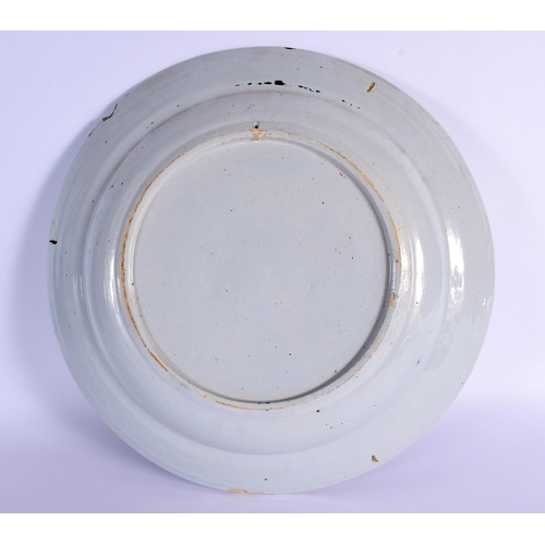 3 - A LARGE 18TH CENTURY DELFT BLUE AND WHITE TIN GLAZED CHARGER painted with landscapes. 34 cm diameter... 